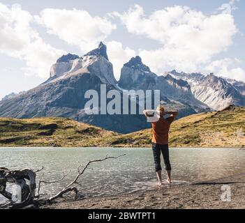 Randonneur dans un paysage montagneux au bord du lac dans le parc national Torres del Paine, Patagonie, Chili Banque D'Images