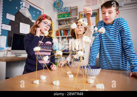 Trois enfants qui ont mis en place la construction pendant une leçon de science Banque D'Images