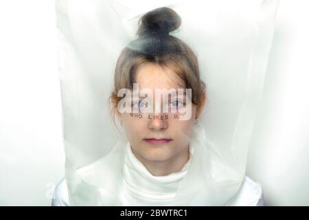 Portrait d'une jeune fille triste portant un masque transparent avec question Banque D'Images