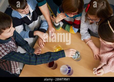 Groupe d'enfants dans une leçon de chimie scientifique Banque D'Images