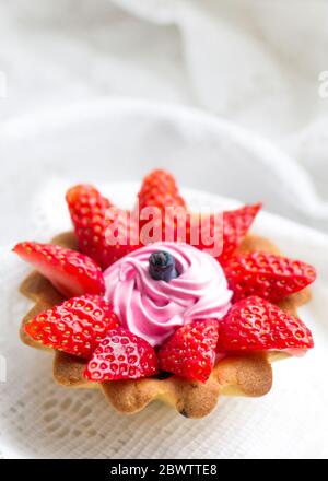 beau gâteau savoureux de gros plan avec fraises, chèvrefeuille et crème rose Banque D'Images