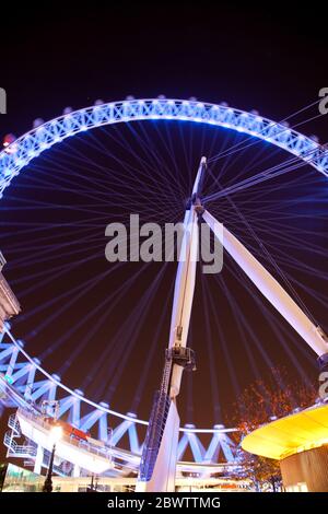 Vue nocturne de la roue d'observation du London Eye éclairée par un éclairage bleu violet Banque D'Images
