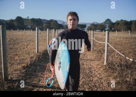 Surfeur handicapé avec planche de surf sur le chemin de la plage Banque D'Images