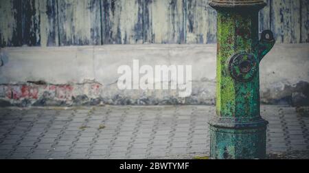 Très vieux avertissement vert hors service pompe à eau de rue debout le long de la chaussée avec l'espace de copie Banque D'Images