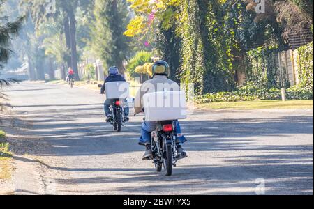Alberton, Afrique du Sud - des coursiers non identifiés sur des motos font la livraison de produits d'achat en ligne pendant l'image de verrouillage national en format horizontal Banque D'Images