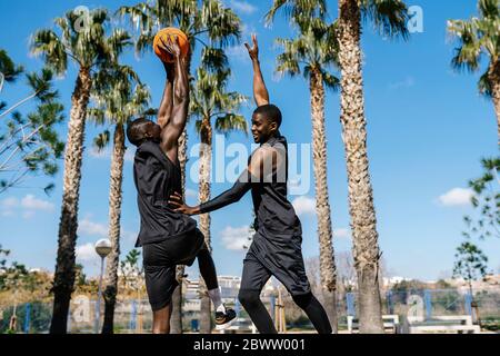 Joueurs de basket-ball jouant au basket-ball sur le terrain en plein air Banque D'Images