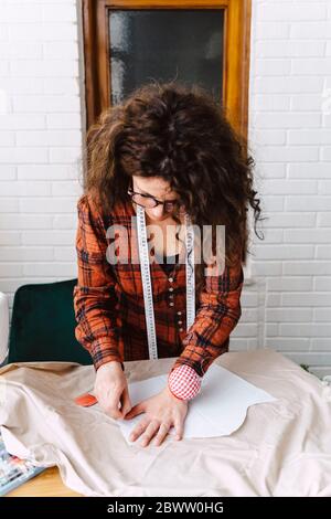Femme épinglant le motif de couture sur la table à la maison Banque D'Images
