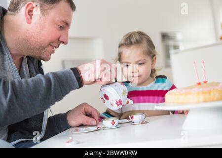 Père et fille jouant avec la porcelaine de poupée Banque D'Images