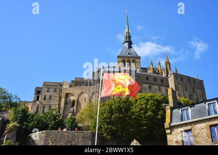 Mont St Michel, France, vue sur l'île, avec drapeau et armoiries de Normandie en premier plan Banque D'Images