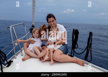 Mère et ses enfants assis sur le pont du bateau pendant le voyage en voilier Banque D'Images