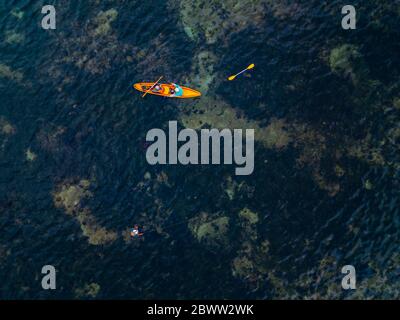 Indonésie, Bali, Sanur, vue aérienne de deux kayakistes passant l'homme pêche dans les eaux peu profondes Banque D'Images