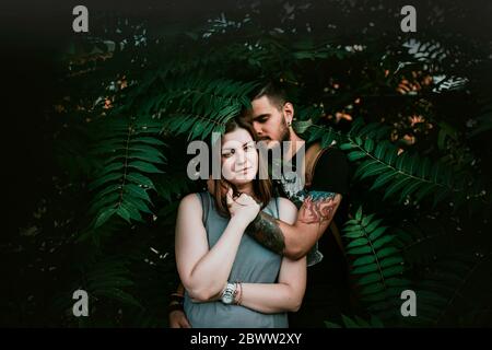 Portrait de jeune couple affectueux en shrubbery Banque D'Images