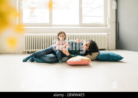 Mère se détendant avec sa fille à l'étage Banque D'Images
