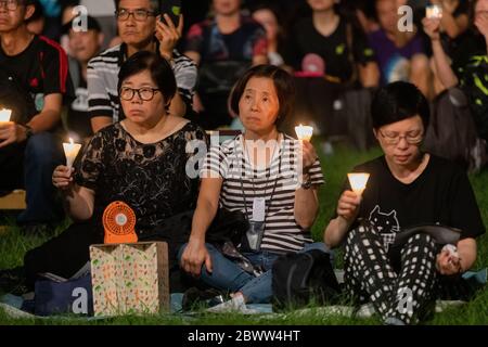 Les participants à une Vigil du massacre de la place Tienanmen à Hong Kong ont semblé plus sombres tout en écoutant des discours sur scène. 4 juin 2019 - Victoria Park, Hong Kong Banque D'Images