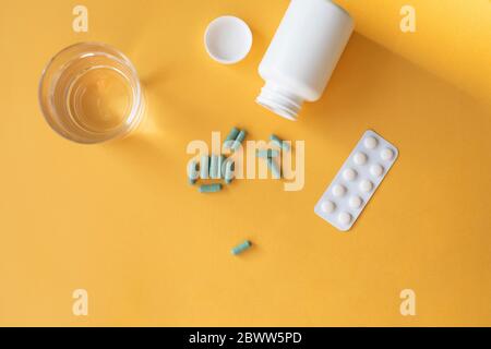 Studio shot de verre d'eau, comprimés blister, flacon de pilules et capsules de supplément nutritionnel Banque D'Images