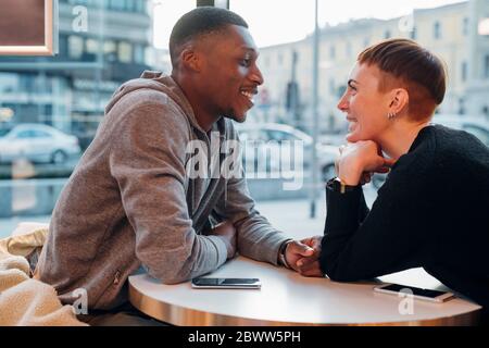 Smiling young couple in a cafe Banque D'Images