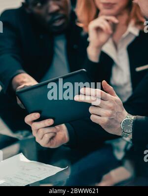 gros plan. équipe d'affaires regardant l'écran d'une tablette numérique. Banque D'Images