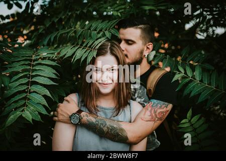 Portrait de jeune couple affectueux en shrubbery Banque D'Images