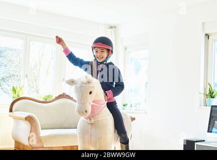 Fille à cheval de jeu à la maison Banque D'Images