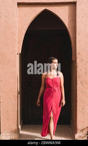 Portrait de la jeune femme devant la porte d'entrée, Merzouga, Maroc Banque D'Images