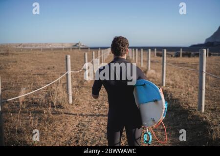 Surfeur handicapé avec planche de surf sur le chemin de la plage Banque D'Images
