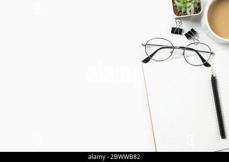 Table de bureau blanche avec carnet avec lignes et fournitures. Vue de dessus avec espace de copie, plan de travail. Banque D'Images