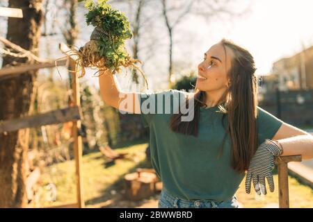 Fière jeune femme tenant le céleri dans le jardin Banque D'Images