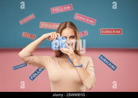 Portrait d'une jeune femme faisant une photo sur un appareil photo avec différentes plaques sur l'arrière-plan Banque D'Images