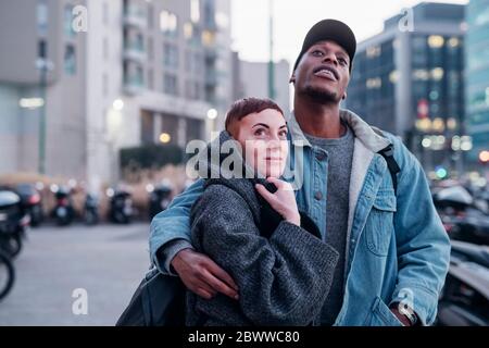 Jeune couple dans la ville au crépuscule, Milan, Italie Banque D'Images