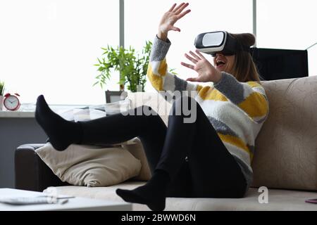 Fille s'amusant à la maison avec des lunettes virtuelles Banque D'Images