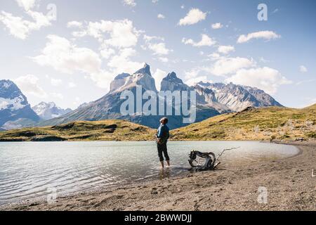 Randonneur dans un paysage de montagne debout dans un lac dans le parc national de Torres del Paine, Patagonie, Chili Banque D'Images