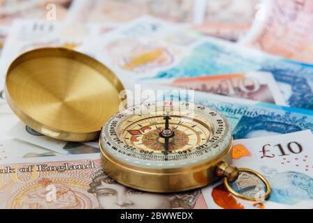 Un compas sur Sterling Money £ dix et cinq livres sterling livres sterling livres sterling pour illustrer l'avenir de l'économie britannique. Changer de direction concept Angleterre Royaume-Uni Grande-Bretagne Banque D'Images