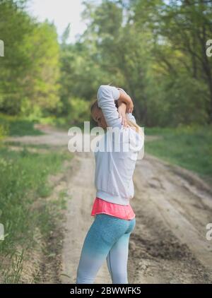 Étirement de jeune Blond Caucasien femelle Forest Runner Banque D'Images