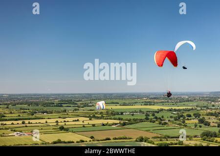 Trois planeurs Hang volant à Westbury White Horse, Angleterre, Royaume-Uni Banque D'Images