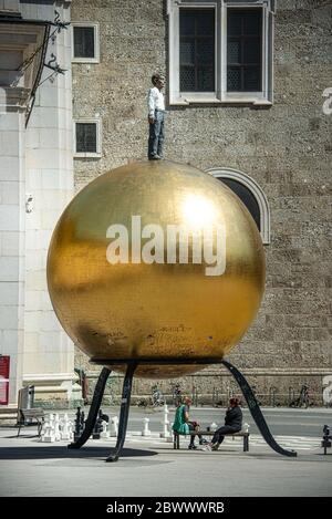 Place Kapitelplatz avec Stephan Balkenhol - Sphaera, sculpture d'un homme sur une sphère dorée et un échiquier géant dans la vieille ville de Salzbourg, Autriche Banque D'Images