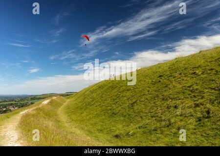 La prairie de craie de Westbury White Horse avec un planeur de main rouge et un couple qui marche à travers le front de la colline, Westbury, Wiltshire, Angleterre, Royaume-Uni Banque D'Images