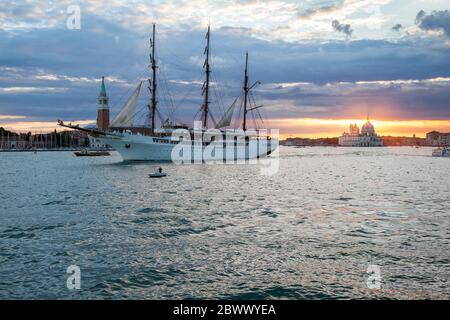 Trois voiliers à voile à bord de mer, MV Sea Cloud ll, quittant Venise, Italie, sous un coucher de soleil chaud Banque D'Images