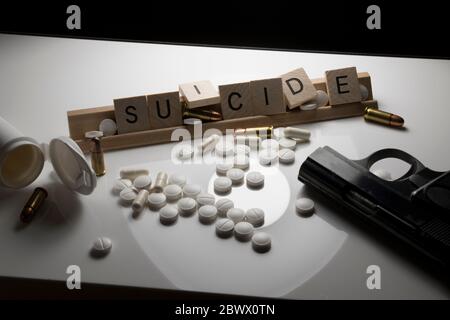 Suicide et sensibilisation à la santé mentale concept suicide orthographié dans le texte avec des coques, des pilules et des armes à feu. Concept de soldats vétérans souffrant de shel Banque D'Images