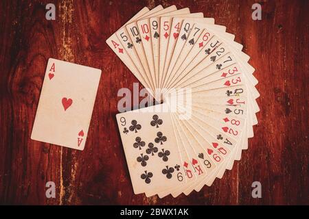 Jeu de cartes disposées en pile circulaire ou en motif ou motif avec ace de coeurs mis de côté sur un fond en bois pour l'exécution de l'illusion ou de la magie Banque D'Images