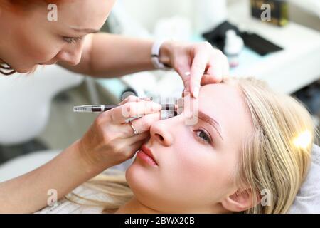 Femme qui fait le maquillage permanent Banque D'Images