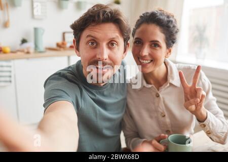 Portrait d'un jeune couple heureux faisant le portrait du selfie pendant le petit déjeuner à la maison Banque D'Images