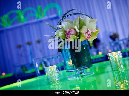 Magnifique cocktail de fleurs d'orchidées et bougies sur table de lucite verte pour une partie de la vue avec réflexion Banque D'Images