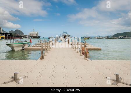 La jetée flottante ou le quai qui permet aux touristes et aux fournitures de venir des bateaux à El Nido Town, El Nido, Palawan Island, les Philippines. Banque D'Images