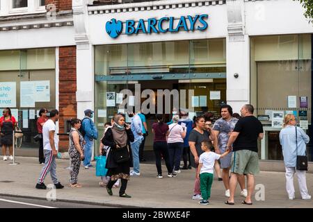 Une foule de personnes à l'extérieur d'une succursale de Barclays Bank. Les restrictions de distanciation sociale ont pour conséquence de longues files d'attente, en particulier pour les banques. Banque D'Images