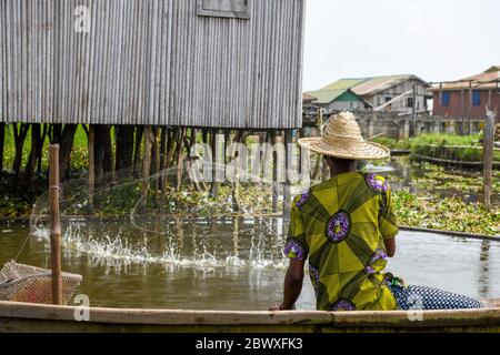 Afrique, Afrique de l'Ouest, Bénin, Lac Nokoue, Ganvié. Un pêcheur jette son filet dans la ville de Ganvié, au bord du lac. Banque D'Images