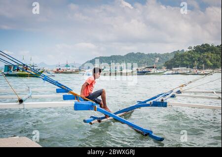 Les capitaines de bateau et leur aide ont mis en place les bateaux à longue queue qui emprennent les touristes vers les lagons, les plages et les îles autour d'El Nido, Palawan, le pH Banque D'Images