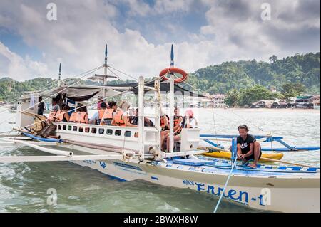 Les capitaines de bateau et leur aide ont mis en place les bateaux à longue queue qui emprennent les touristes vers les lagons, les plages et les îles autour d'El Nido, Palawan, le pH Banque D'Images