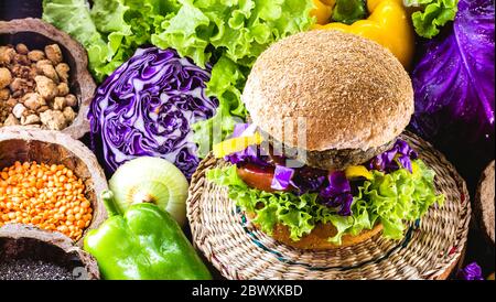 grand hamburger vegan rôti, fait de pois chiches et de soja avec des protéines. Concept de vie saine et végétarienne. Nourriture colorée, poivrons, chou rouge, à Banque D'Images