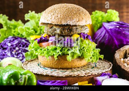 grand hamburger vegan rôti, fait de pois chiches et de soja avec des protéines. Concept de vie saine et végétarienne. Nourriture colorée, poivrons, chou rouge, à Banque D'Images