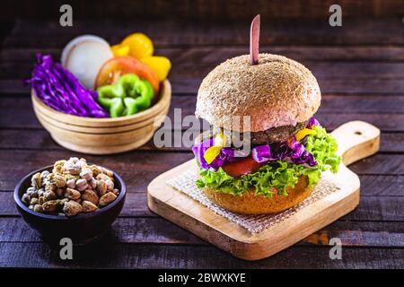 hamburger végétarien, rôti et prêt à consommer. Concept de vie saine et végétarienne. En-cas sans viande à base de soja et de pois chiches avec légumes frais Banque D'Images